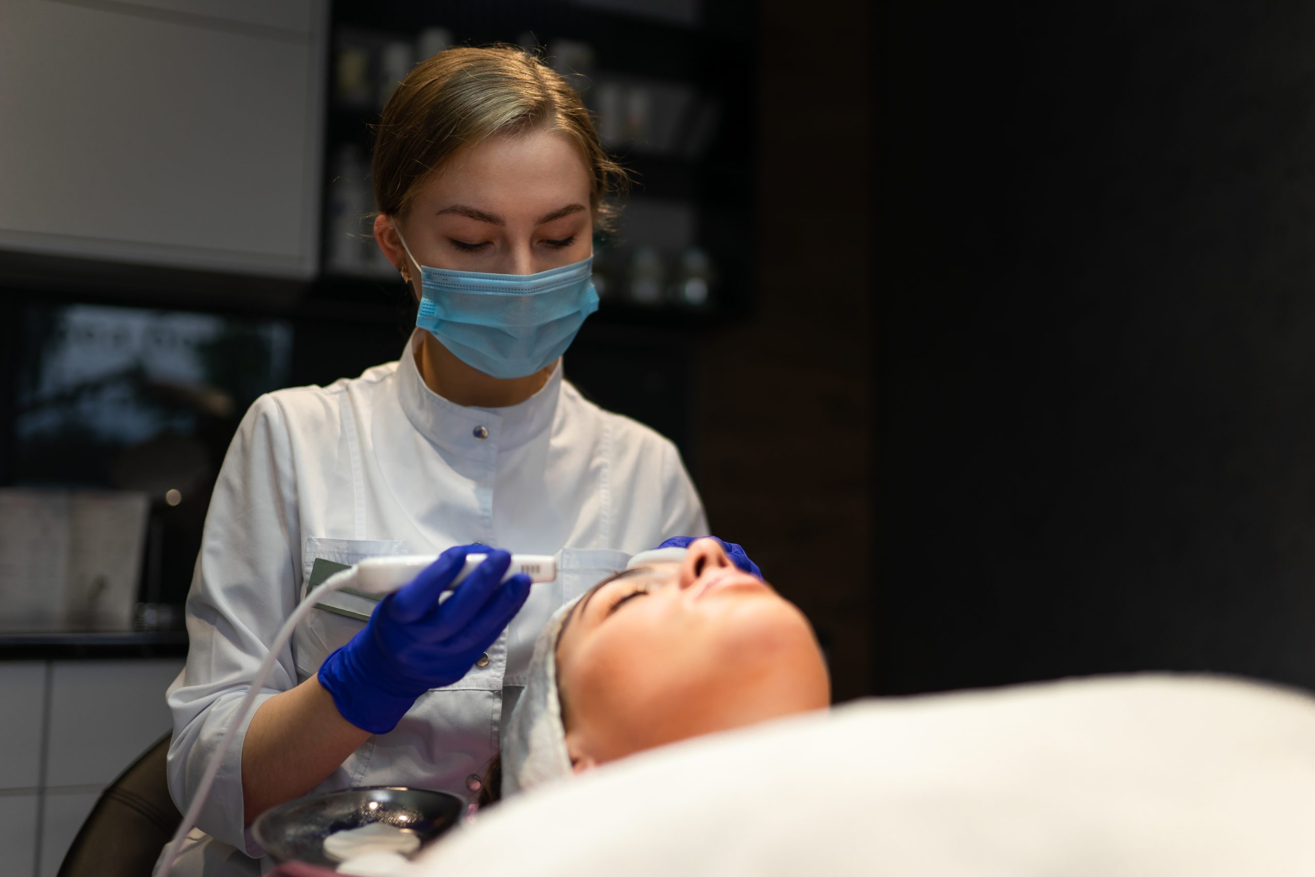 Uma paciente deitada recebendo o procedimento de Terapia Capilar com Laser Led e Infravermelho