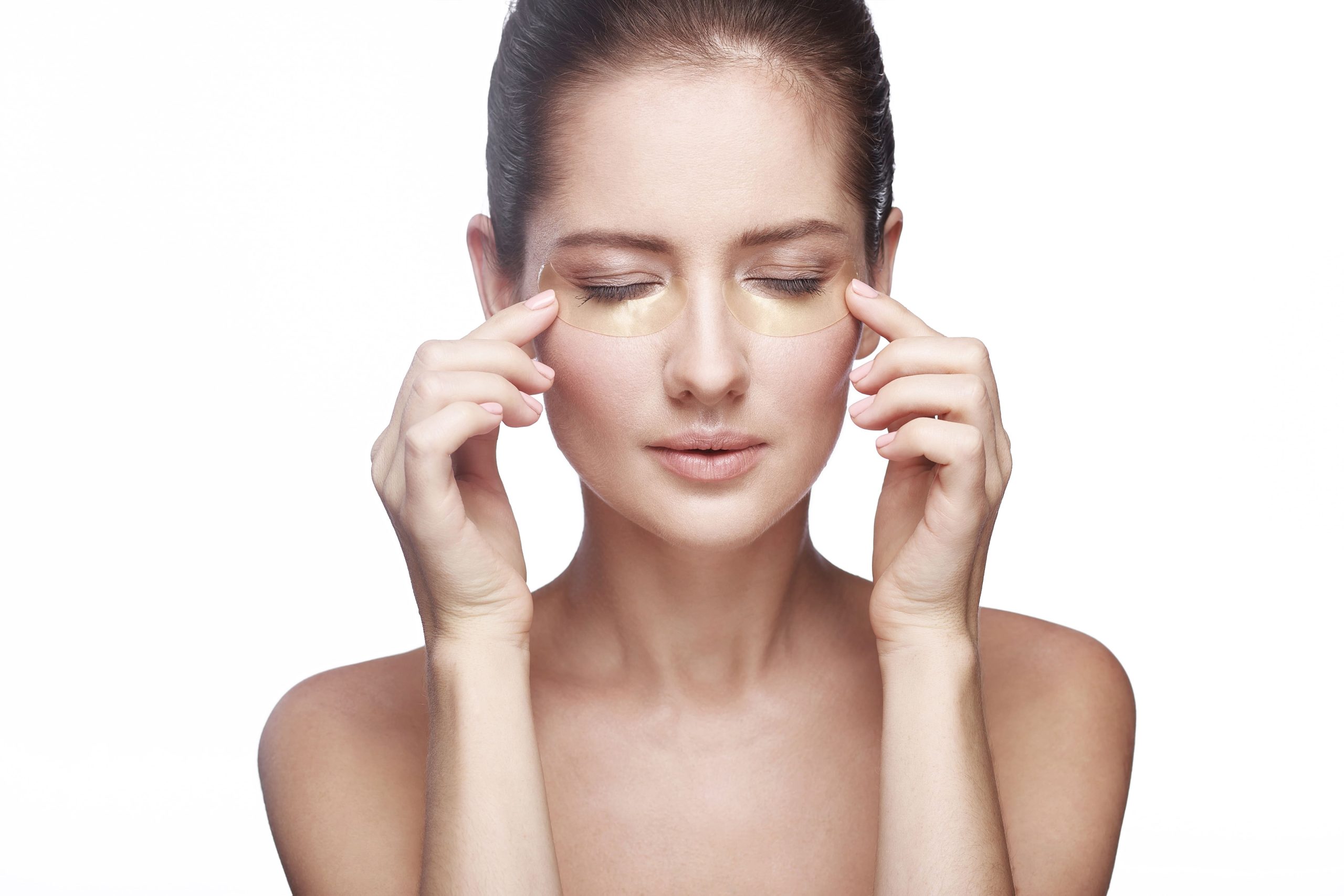 Mulher com olhos fechados e com os dedos passando sobre as olheiras.