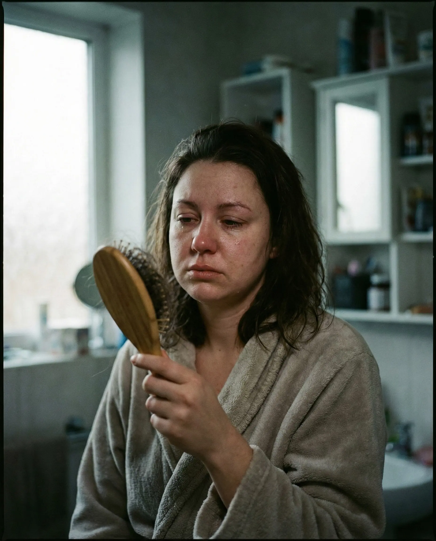 Mulher pós-bariátrica olhando no espelho com queda de cabelo e fadiga - problema tratado com soroterapia endovenosa